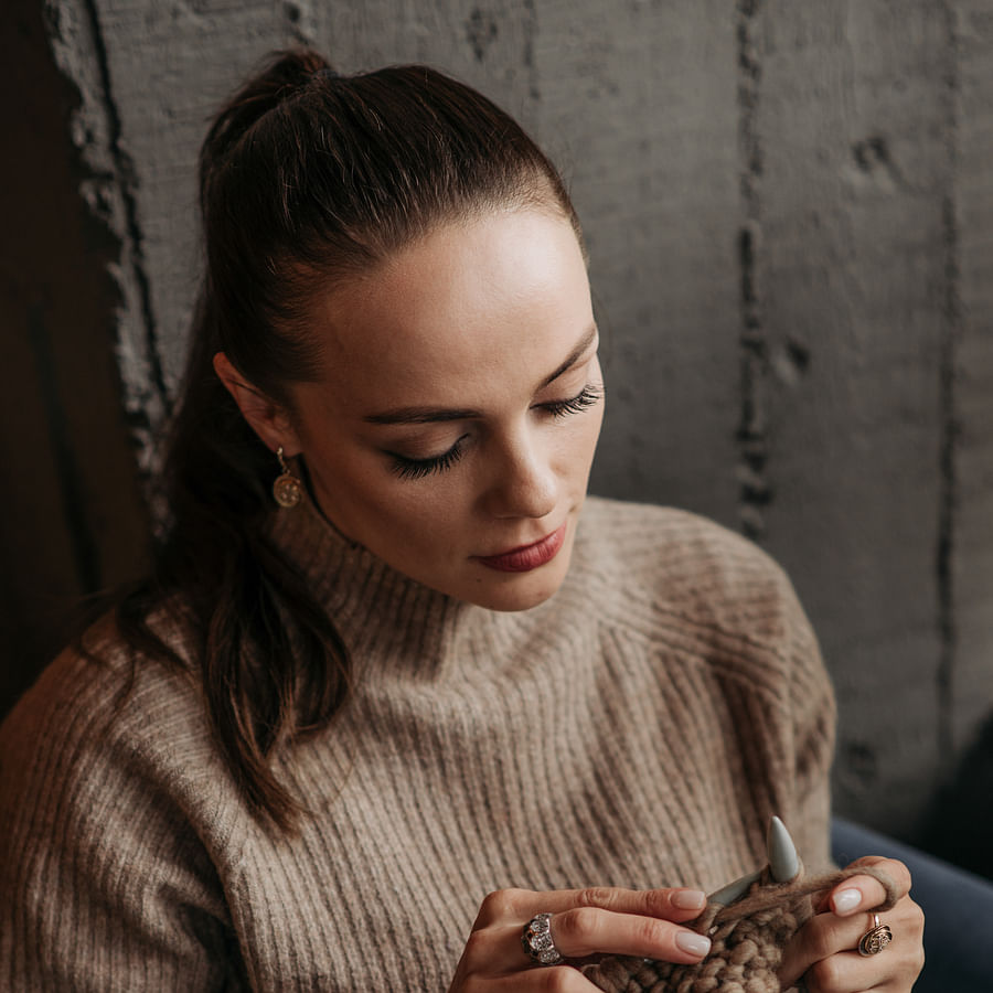 Colorful yarn balls with knitting needles and a cozy cup of hot chocolate on a wooden table